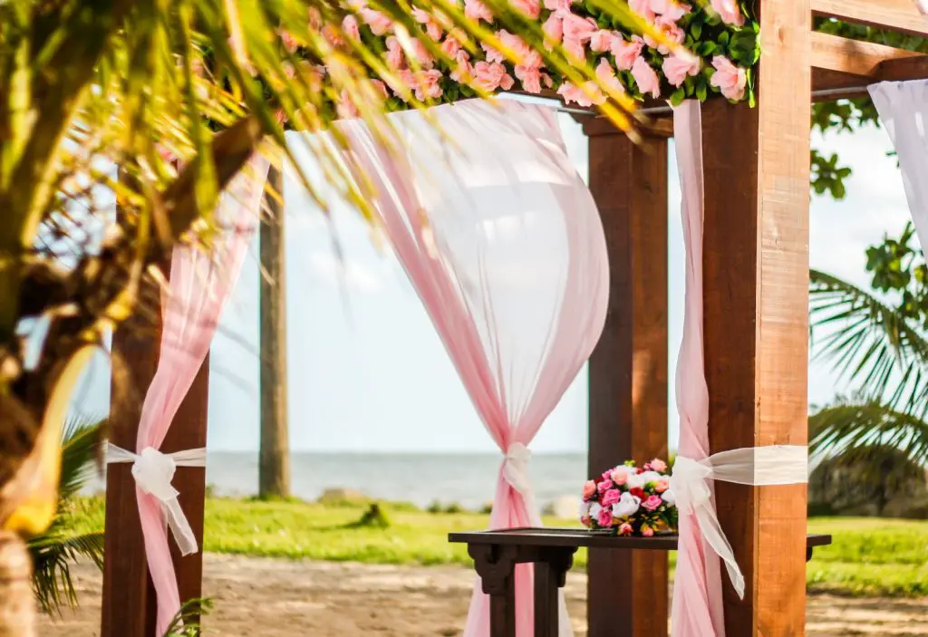 brown wooden gazebo with pink curtain