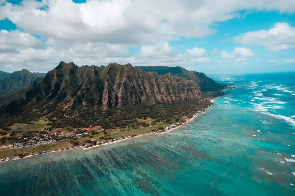 island surround by green sea under cloudy sky