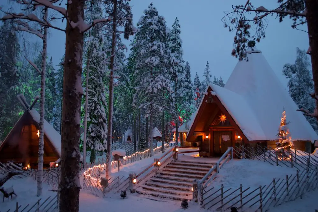 a cabin in the woods is lit up with christmas lights