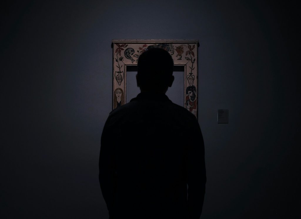 silhouette of person facing an empty photo frame